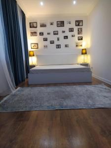 een slaapkamer met een bed en een muur met foto's bij Mardakan Villa in Baku
