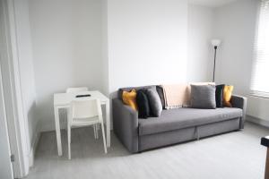 a living room with a couch and a table at Twelve Thirty Serviced Apartments - 2 Croydon in South Norwood