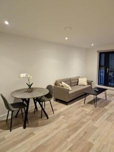 een woonkamer met een tafel en een bank bij Modern-New Build Apartment in Birmingham in Birmingham