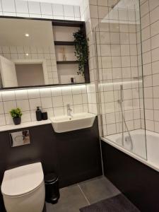 y baño con aseo, lavabo y ducha. en Modern-New Build Apartment in Birmingham, en Birmingham