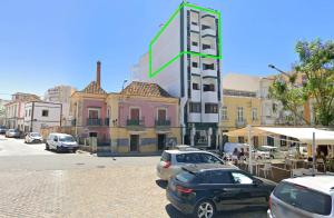 uma rua com carros estacionados em frente a um edifício em À dos Reis em Faro