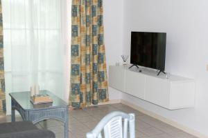 una sala de estar con TV en un armario blanco en Apartment in South Tenerife with heated pool, en Costa del Silencio