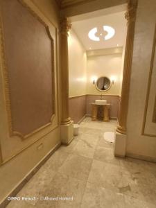 uma casa de banho com um WC e um espelho redondo em فلل نادي الصيد em Cidade 6 de Outubro