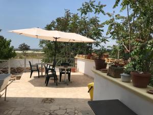 a patio with an umbrella and tables and chairs at Vacanze Fuori Porta in Grottaglie