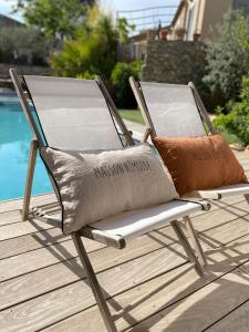 a folding chair with two pillows sitting on a deck at le pool house in Nîmes