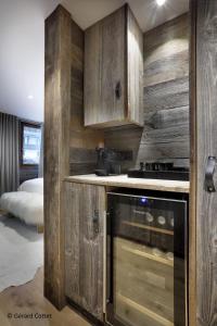 a kitchen with wooden cabinets and a stove at Studio Megève centre in Megève