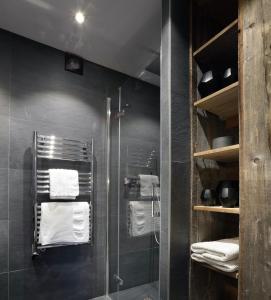 uma casa de banho com uma cabina de duche em vidro e toalhas em Studio Megève centre em Megève