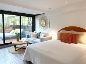 a bedroom with a large bed and a couch at AmazINN Places Casco Viejo private Rooftop and Jacuzzi in Panama City
