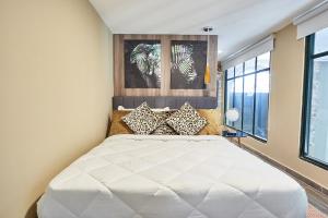 Un dormitorio con una gran cama blanca con almohadas. en AmazINN Places Casco Viejo Design Pool X, en Panamá 23 fotos más