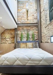 Cama grande en habitación con pared de piedra en AmazINN Places Rooftop and Design Pool X, en Panamá