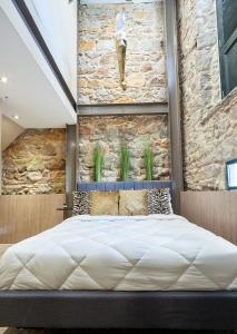 a large bed in a room with a stone wall at AmazINN Places Rooftop and Design Pool X in Panama City