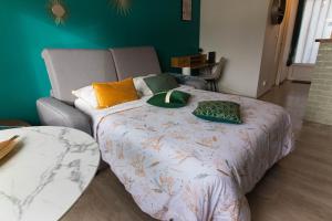 a bed with pillows on it in a room at Le Pic'Vert de Bergerac - Studio - Au calme - Parking gratuit - Fibre in Bergerac