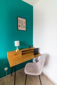a desk in a room with a chair and a lamp at Le Pic'Vert de Bergerac - Studio - Au calme - Parking gratuit - Fibre in Bergerac
