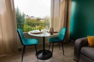 a table and chairs in a room with a window at Le Pic'Vert de Bergerac - Studio - Au calme - Parking gratuit - Fibre in Bergerac