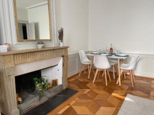 a living room with a fireplace with a table and a mirror at V&V CENTRE Neuchatel in Neuchâtel