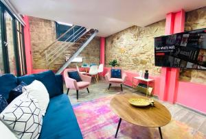 a living room with a blue couch and a table at AmazINN Places Casco Viejo Pink Desing and Pool IX in Panama City