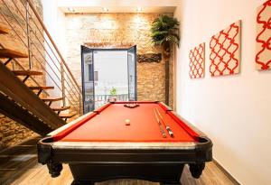a red pool table in a room with stairs at AmazINN Places Casco Viejo Billiard table and Pool in Panama City