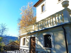 a white building with a balcony on top of it at La Fioraia bilocale con giardino in LʼAquila