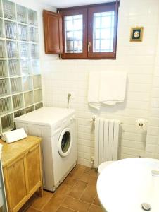 a bathroom with a washing machine and a sink at La Fioraia bilocale con giardino in LʼAquila