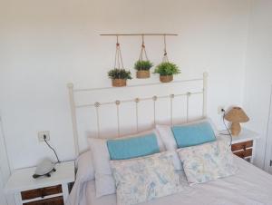 een slaapkamer met een bed met drie planten aan de muur bij Barlovento in La Canuta