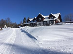 una casa en una carretera cubierta de nieve frente a una casa en Chata Hubertka Krkonoše, en Vítkovice