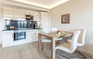 a kitchen with a wooden table and white cabinets at Princess in Binz