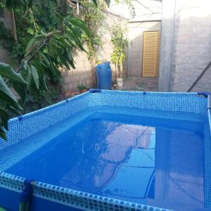 una piscina de azulejos azules en un patio en ARTE Y VINO en Maipú