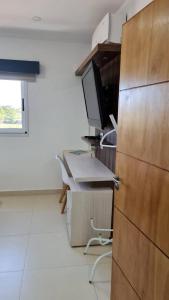 um quarto com uma secretária, uma televisão e uma cadeira em Valentina em Encarnación