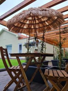 a wooden table with an umbrella on a patio at VILLAS com piscina in Vila Nova de Gaia