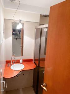 y baño con lavabo y espejo. en Hermoso loft en zona Recoleta c pileta! en Buenos Aires