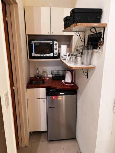 una pequeña cocina con fregadero y microondas en Hermoso loft en zona Recoleta c pileta! en Buenos Aires