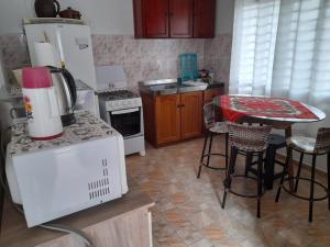 a kitchen with a refrigerator and a table with chairs at Hospedagem Tia Nena in Pomerode