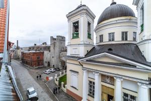 a building with a clock tower on top of it at Roofs of the Old Tallinn Guest House in Tallinn