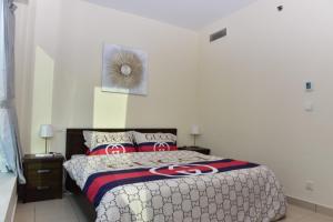 a bedroom with a large bed with red pillows at 1 BEDROOM APARTMENT in DUBAI MARINA & JBR in Dubai