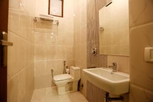 a white bathroom with a toilet and a sink at Hotel Devrana Delhi in New Delhi