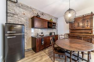 a kitchen with a table and a refrigerator at Roofs of the Old Tallinn Guest House in Tallinn