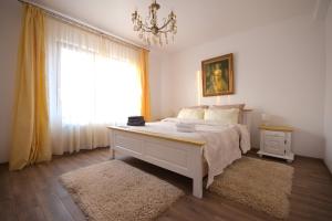 a bedroom with a bed with a chandelier and a window at casa Flav in Iaşi