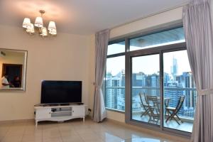 Telewizja i/lub zestaw kina domowego w obiekcie 1 BEDROOM APARTMENT in DUBAI MARINA & JBR