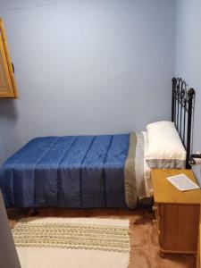 ein Schlafzimmer mit einem Bett mit einer blauen Decke darauf in der Unterkunft Casa Rustica a pie de montaña in Cullera
