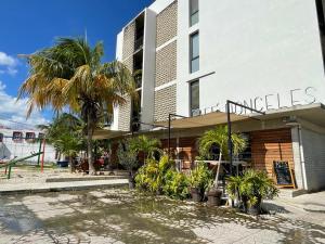 a hotel with palm trees in front of a building at Mangle By Andiani in Cancún