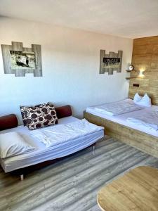 a room with two beds and a table at Apartmány Almberg in Philippsreut