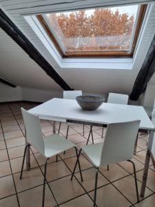 a table and chairs in a room with a skylight at Stupenda mansarda in centro a Torino in Turin