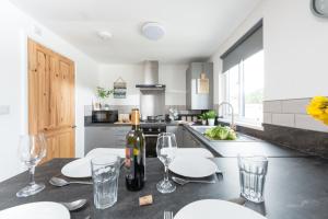 a kitchen with a table with glasses and a bottle of wine at Wheal Rose -Beautifully Fitted Lodge Helston Cornwall in Helston
