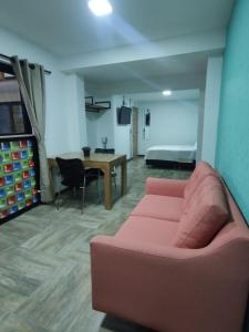sala de estar con sofá rosa y dormitorio en CoLinkHouse Hotel en Medellín