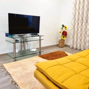 a living room with a yellow couch and a tv at VILLAS com piscina in Vila Nova de Gaia
