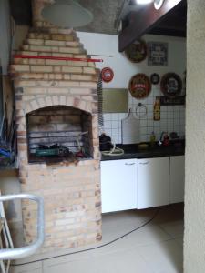 a kitchen with a brick oven in a kitchen at DIAS INESQUECÍVEIS NO PERÓ in Cabo Frio