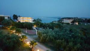uma vista da cidade à noite com um campo de ténis em Villa Evita , suites 1, Athytos,63m2,a/c,privacy em Afitos