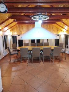 ein Esszimmer mit einem Tisch, Stühlen und einer Uhr in der Unterkunft Apartman LELI in Kupres