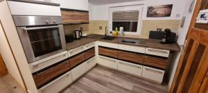 a kitchen with white cabinets and stainless steel appliances at Ferienwohnung Gleißner in Garz-Usedom