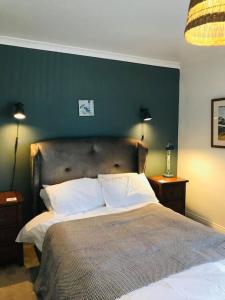 ein Schlafzimmer mit einem großen Bett und einer grünen Wand in der Unterkunft Spacious 3 bed house near beach! in Lowestoft